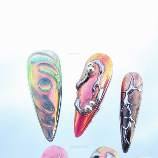 Chrome Wave press-on nails shown in close-up with iridescent blue, pink, and metallic chrome curves