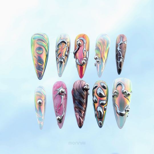 Chrome Wave press-on nails laid out, featuring iridescent blue, pink, and metallic chrome curves with raised details.