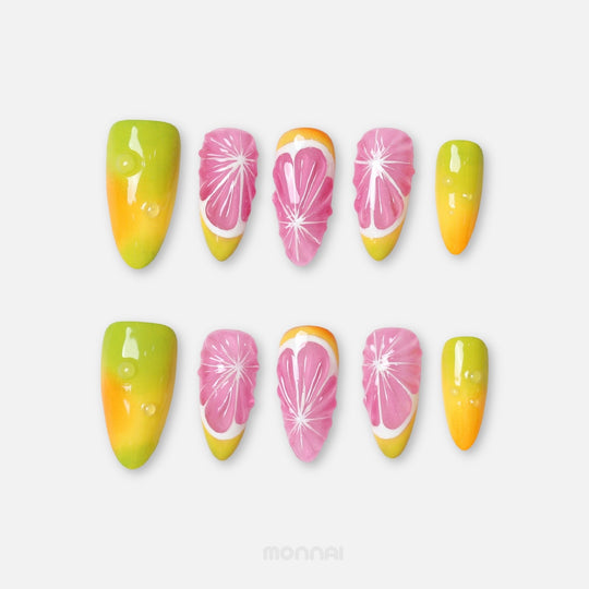 Citrus Splash press-on nails laid out in two rows, with glossy citrus slice art, yellow-green gradients, and pink accents.