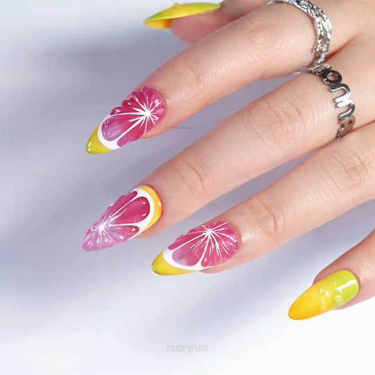 Citrus Splash press-on nails worn on hand, showing pink citrus slice art with yellow tips and glossy accents.