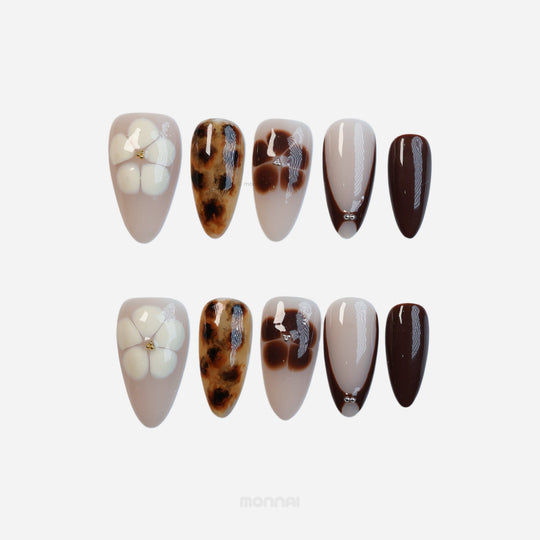 Classic Petals press-on nails in soft beige and brown with tortoiseshell and sculpted flower details, shown in laid-out sets