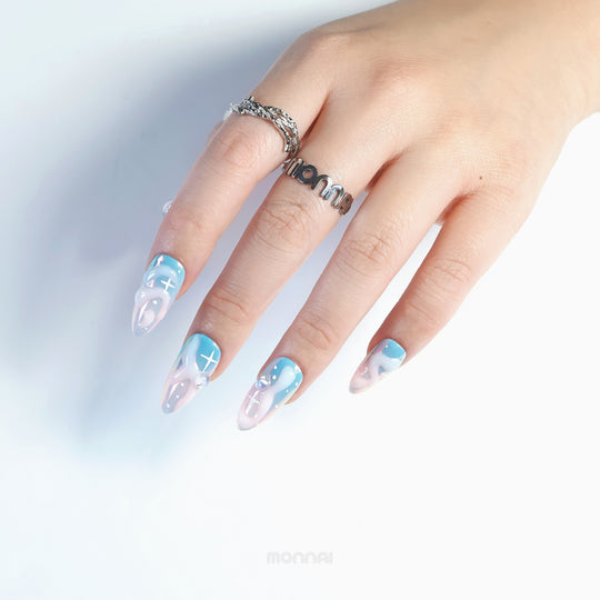 Cloud Dream press-on nails on hand, blue-pink aura fade with glossy chrome shine and cloud-like 3D details