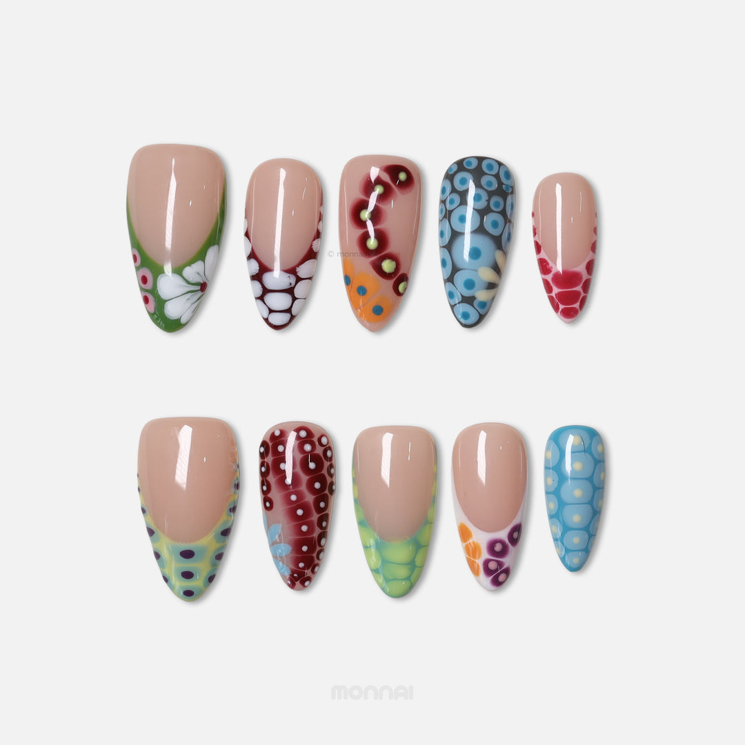 Coral Reef press-on nails laid out with colorful abstract blooming gel and glossy high-fashion patterns.