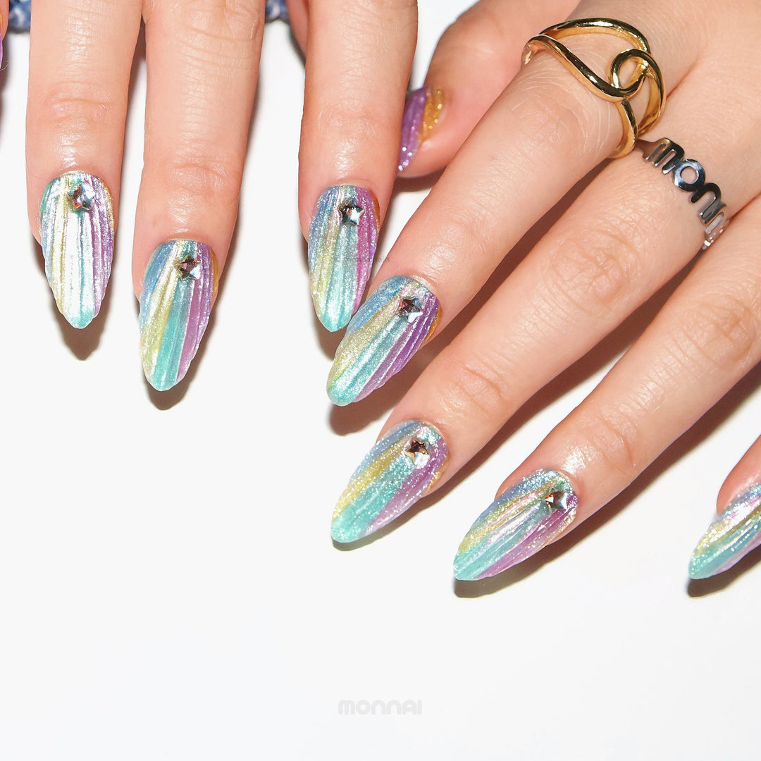 Cosmic Glow press-on nails worn on hands, pastel iridescent gradient with 3D seashell texture and star rhinestones.