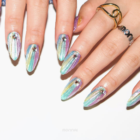 Cosmic Glow press-on nails worn on hands, pastel iridescent gradient with 3D seashell texture and star rhinestones.