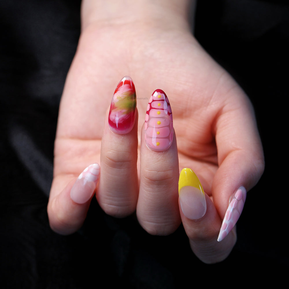Croc Charm press-on nails worn on hand, with glossy red-pink crocodile texture, yellow accents, and soft gradients