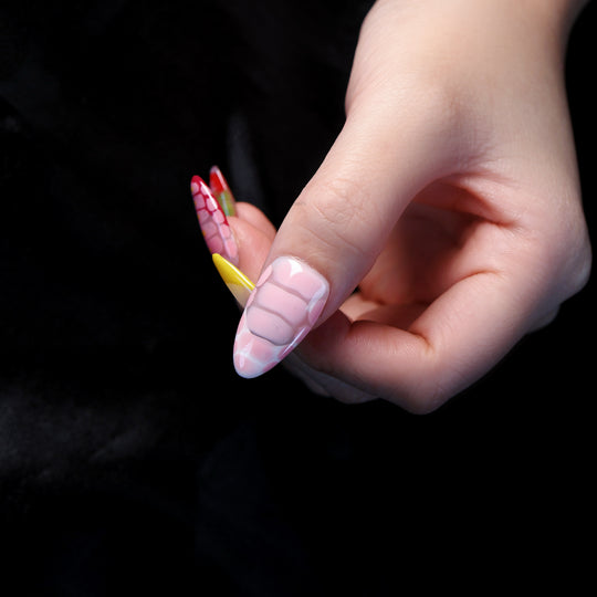 Croc Charm press-on nails in close-up, with pink crocodile texture, bright yellow and red accents, and glossy raised detailing.