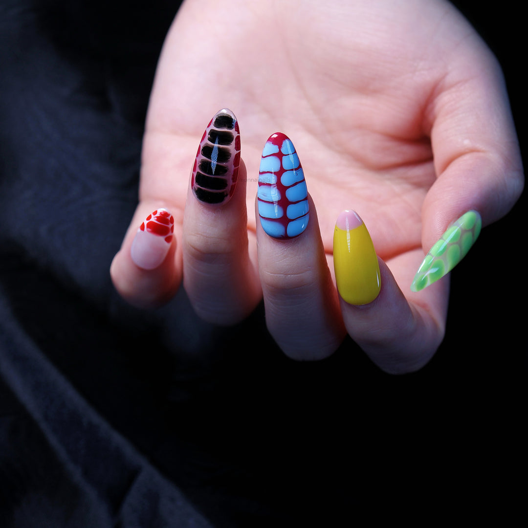 Croc Charm press-on nails worn on hand, showing bold crocodile texture in bright blue, black, red, yellow and green