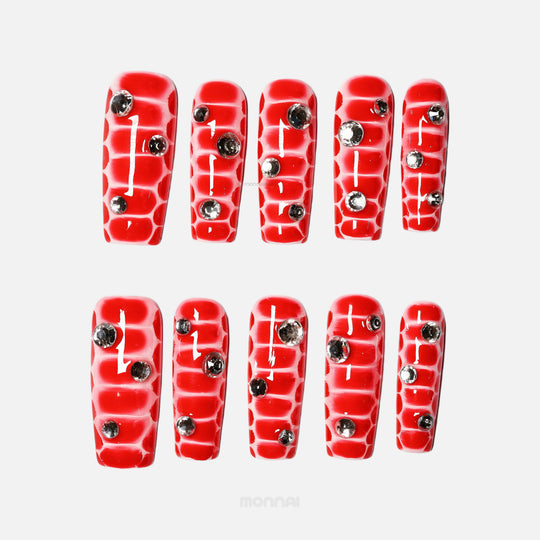 Crocodile Chic red press-on nails with crocodile texture and clear rhinestones, shown laid out in two rows