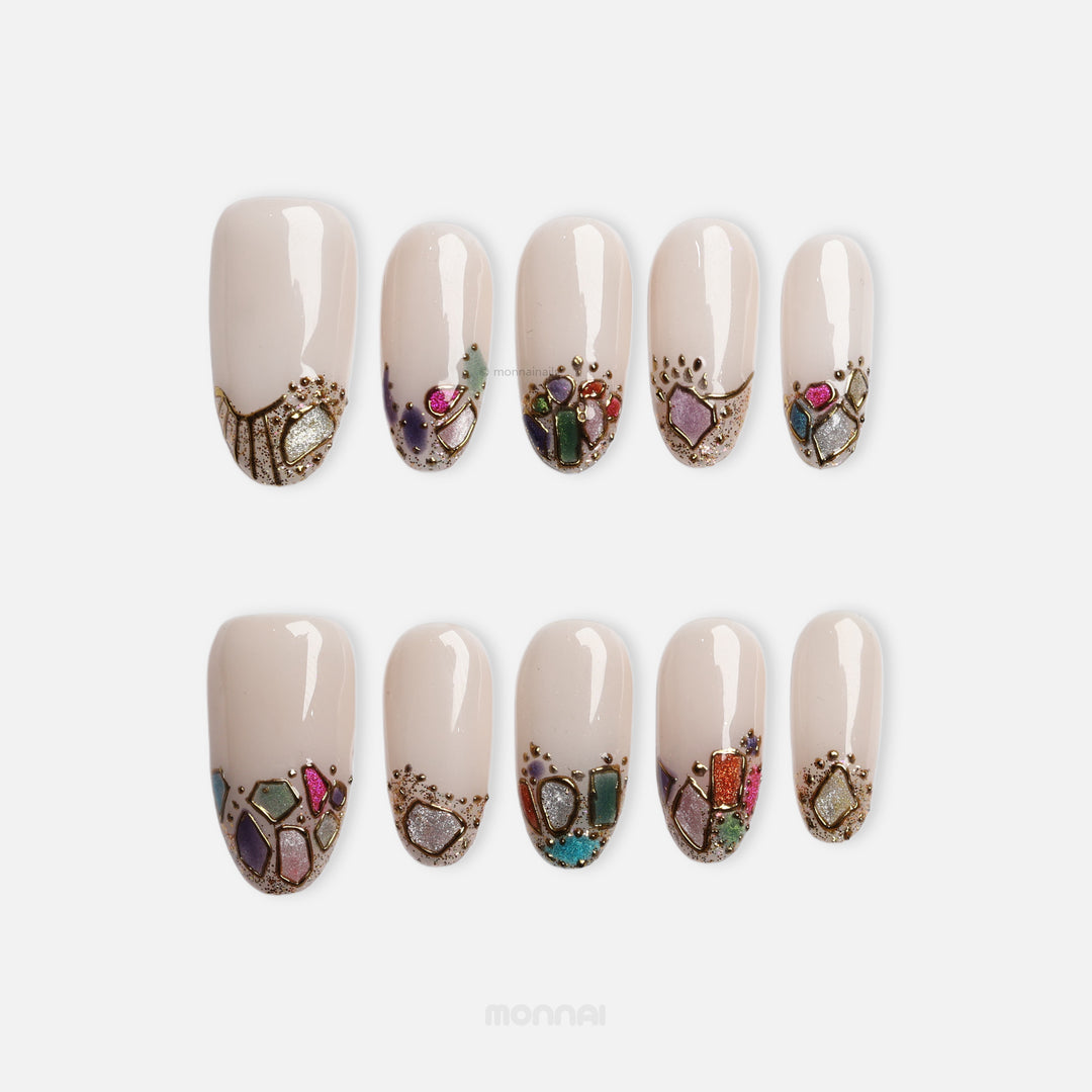 Crown Jewels press-on nails with sheer nude base and mosaic-style jewel accents outlined in gold