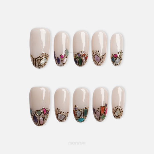Crown Jewels press-on nails with sheer nude base and mosaic-style jewel accents outlined in gold