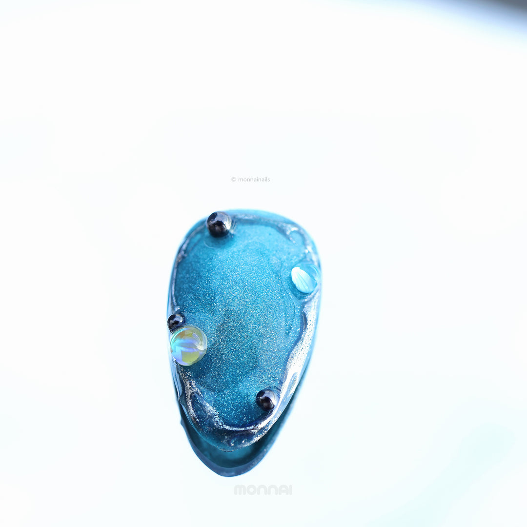 Cyber Galaxy press-on nails close-up, blue cat-eye shimmer with chrome and celestial accents