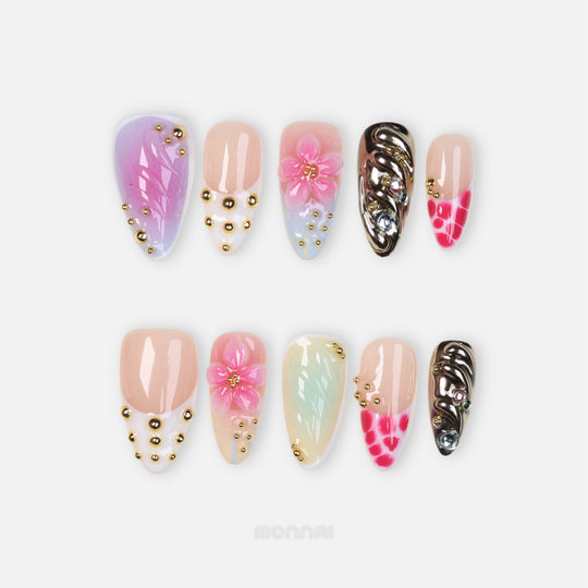 Cyber Sakura press-on nails laid out with pastel ombré bases, 3D floral details, gold studs, and silver chrome accents