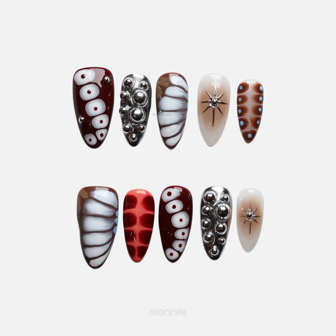 Dark Elegance press-on nails in close-up, with crocodile-print details, chrome spheres, and bold black, brown, cream, and red contrast