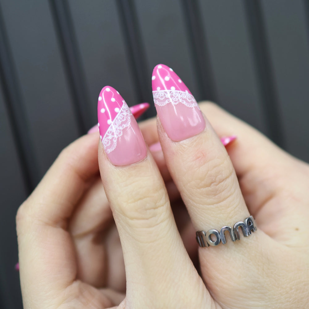 Dot & Lace press-on nails on hand, soft pink with magenta tips, white lace and polka dots, glossy finish