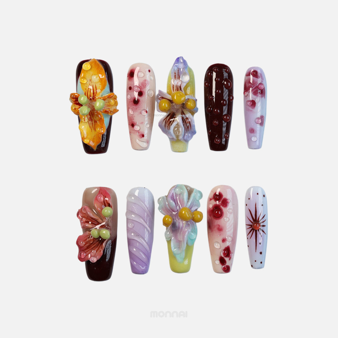 Dreamscape Blossoms botanical press-on nails laid out with 3D petals, dewdrops, and rich ochre, bordeaux, lavender accents