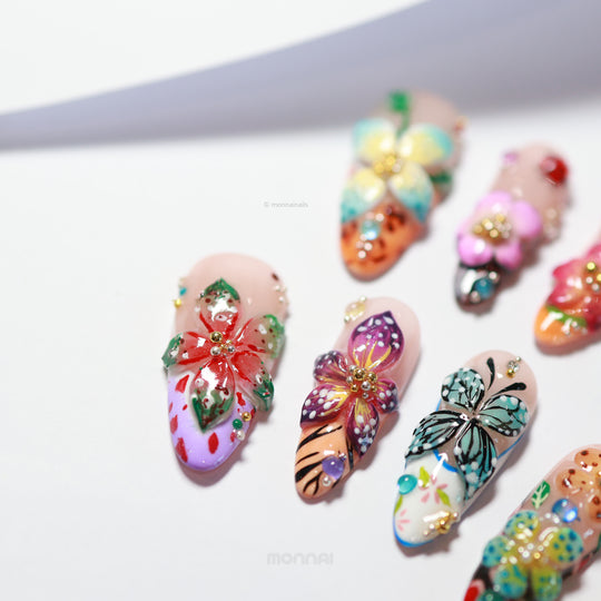 Enchanted Garden press-on nails laid out with vivid 3D hand-painted butterflies and flowers in a colorful botanical design