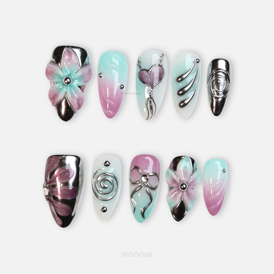 Enchanted Love press-on nails with pastel pink and mint florals, chrome hearts, and sleek glossy details in a laid-out set