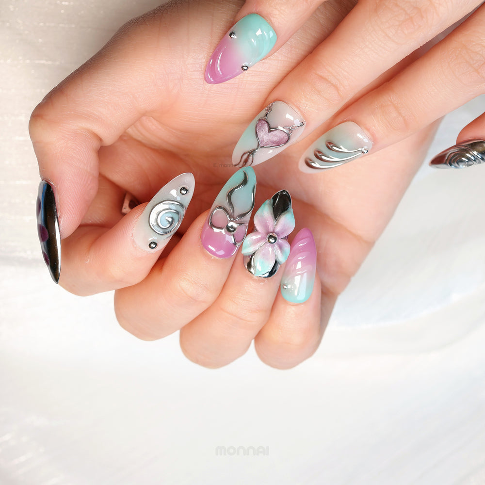 Enchanted Love press-on nails worn on hand, with pastel pink and mint chrome hearts and floral accents.