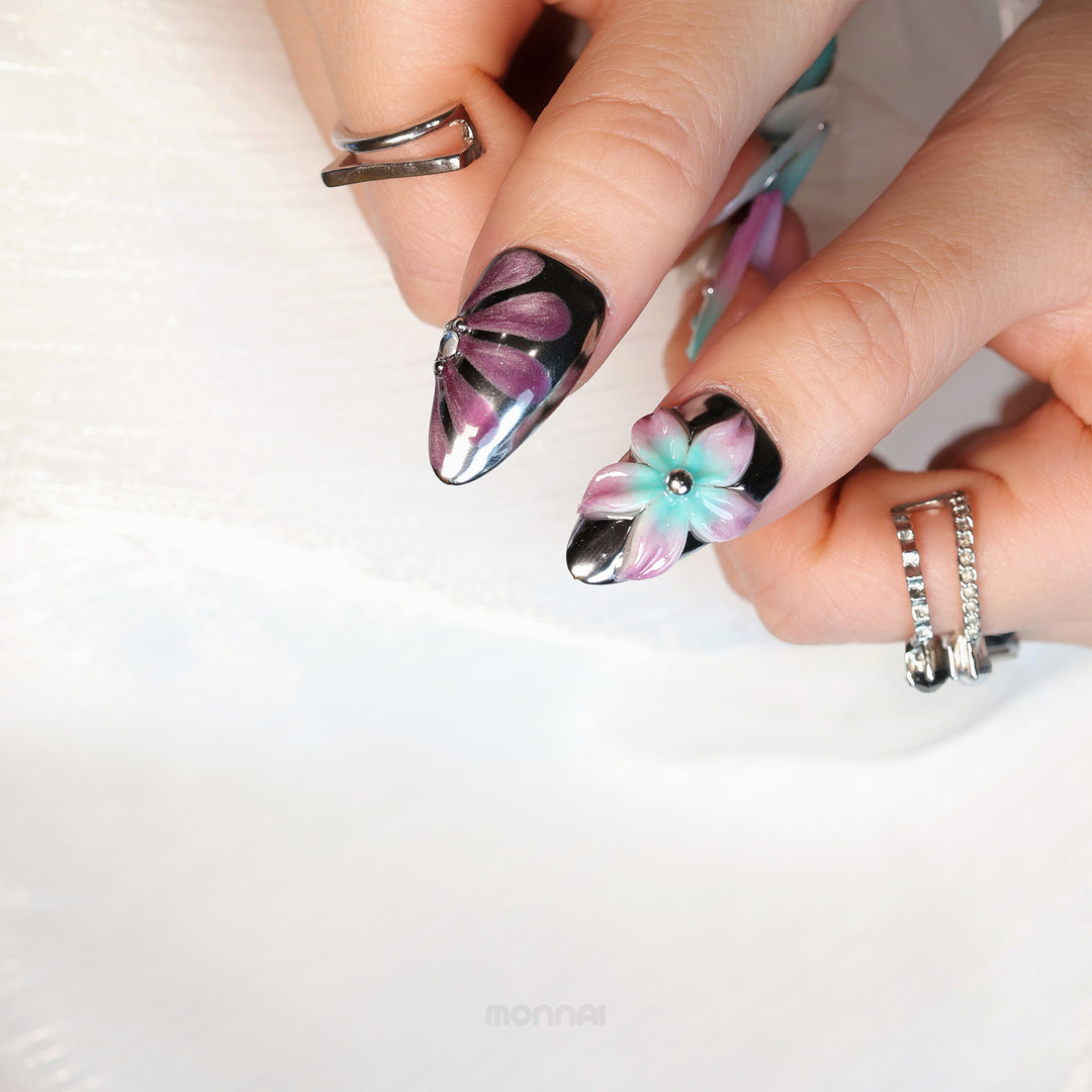 Enchanted Love press-on nails worn on hand with chrome accents, purple floral detail and mint-pink flower motif