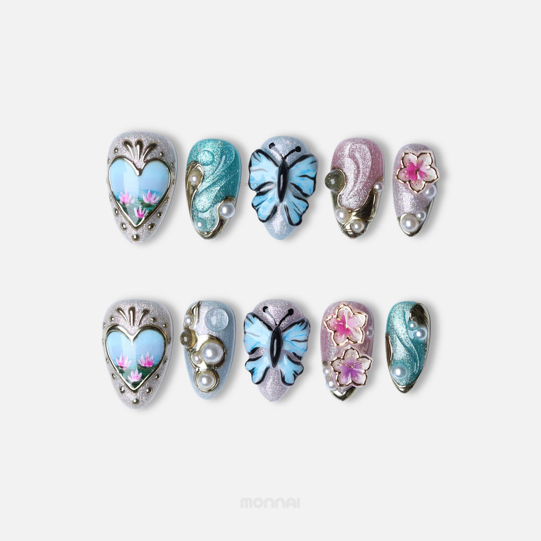 Ethereal Reverie press-on nails laid out in two rows, with butterfly, floral and pearl accents in soft shimmer.