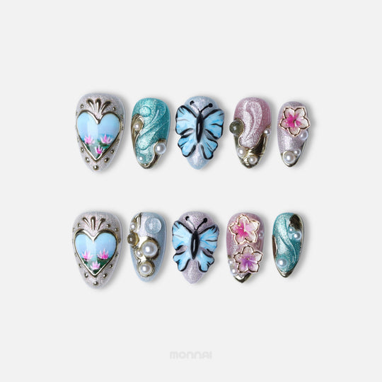 Ethereal Reverie press-on nails laid out in two rows, with butterfly, floral and pearl accents in soft shimmer.