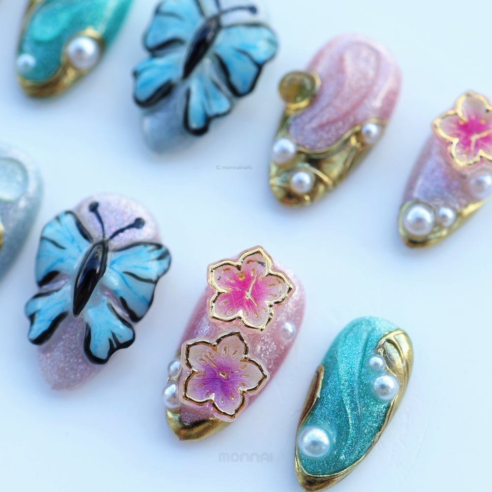 Ethereal Reverie press-on nails in close-up, with butterfly and floral details, pearl accents, and soft shimmer.