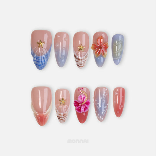 Finding Summer press-on nails laid out with sheer nude, pastel blue and coral accents, shell textures, hibiscus details, and gold starfish charms
