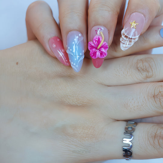 Finding Summer press-on nails worn on hands with pastel blue, coral, hibiscus and shell detail