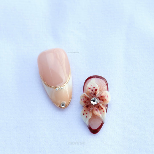 Flame Fleur press-on nails with nude and burgundy floral accents, shown in close-up