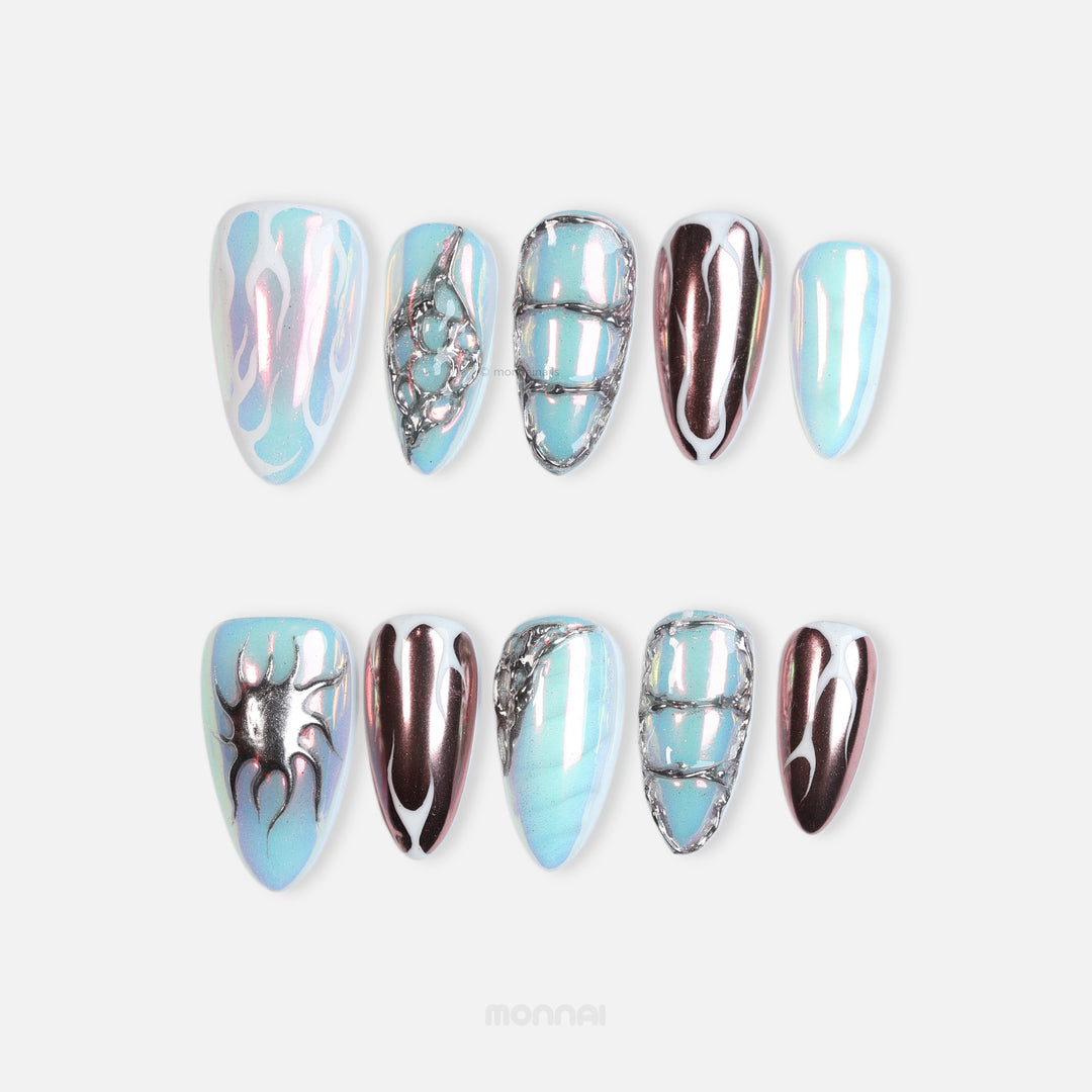 Flame Gradient press-on nails laid out in icy blue with chrome flame details and glossy futuristic finish