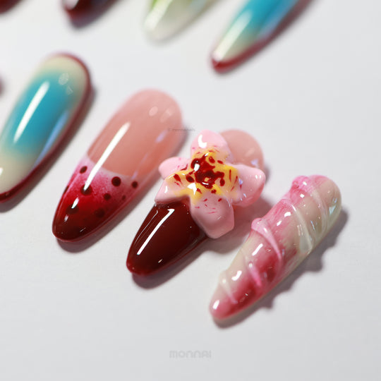 Floral Bliss press-on nails laid out in close-up, with cherry red, pastel pink, sky-blue aura, and a 3D floral accent.