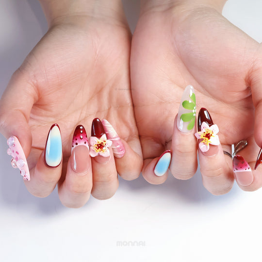 Floral Bliss press-on nails on hands with cherry red, pastel blue gradients, green botanicals and floral 3D accents.