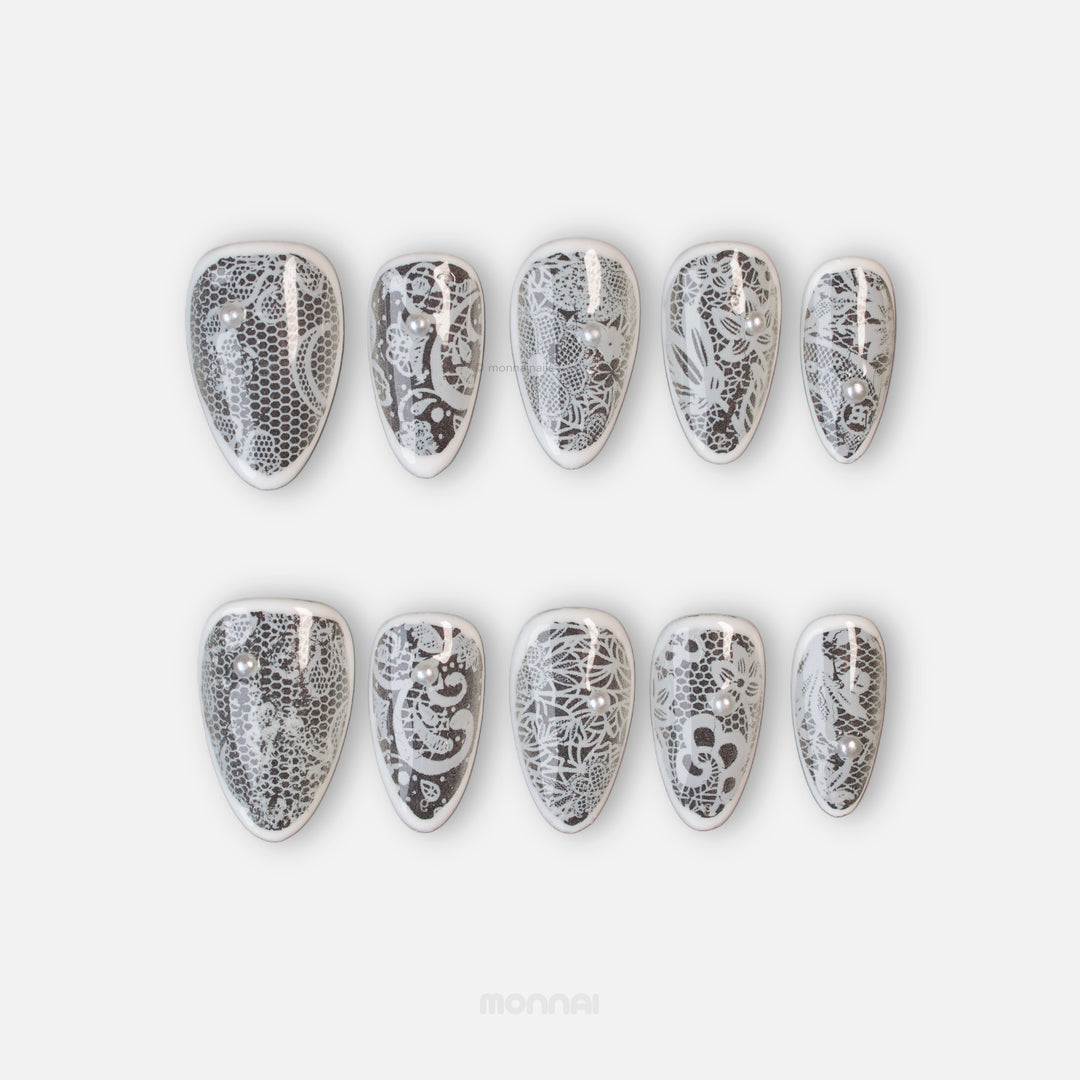 Floral Veil press-on nails laid out, showing sheer white vintage floral lace and micro pearls.