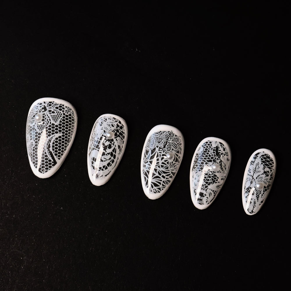Floral Veil press-on nails in close-up, showing white floral lace patterns over sheer bases with micro pearls.