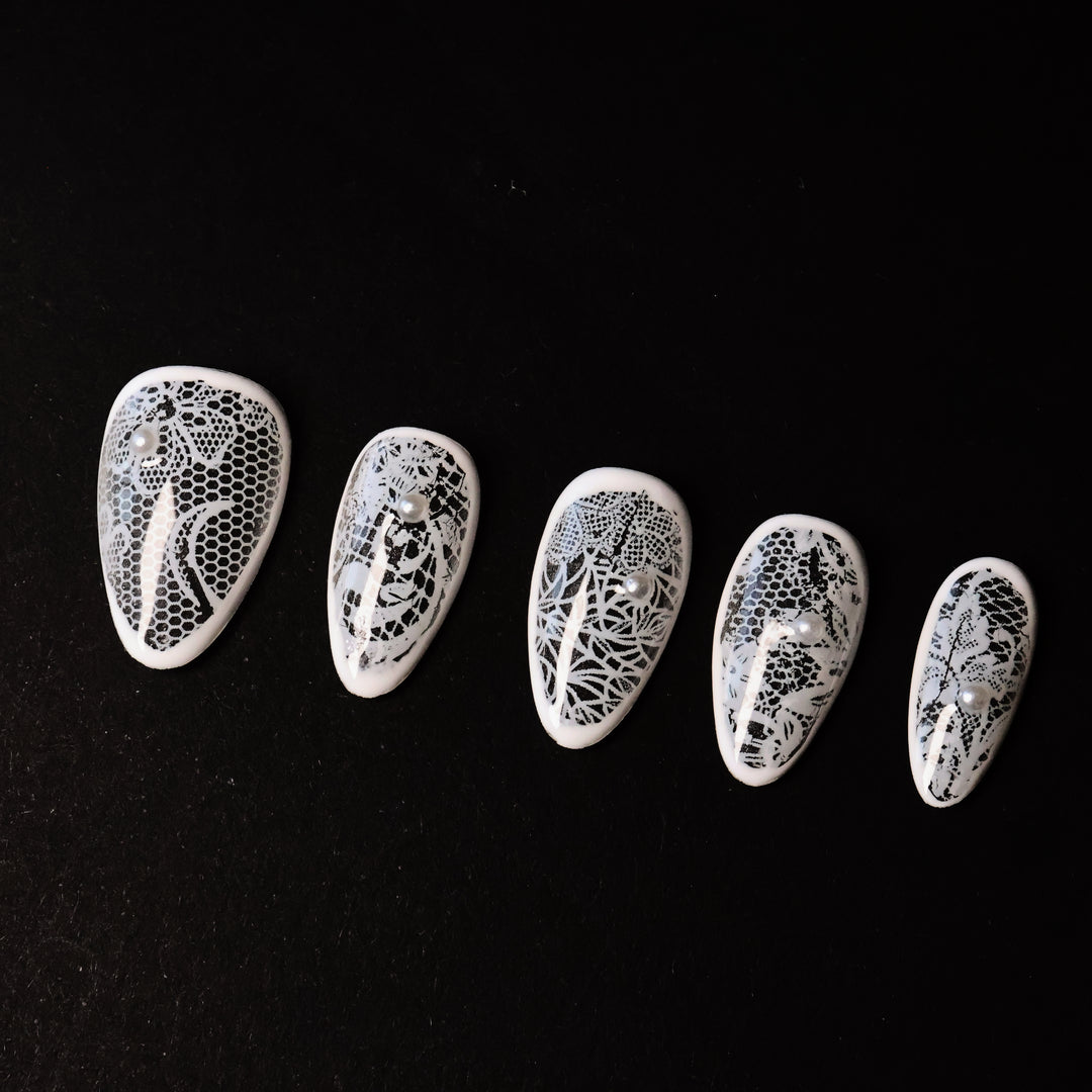 Floral Veil press-on nails in close-up, showing white floral lace patterns over sheer bases with micro pearls.