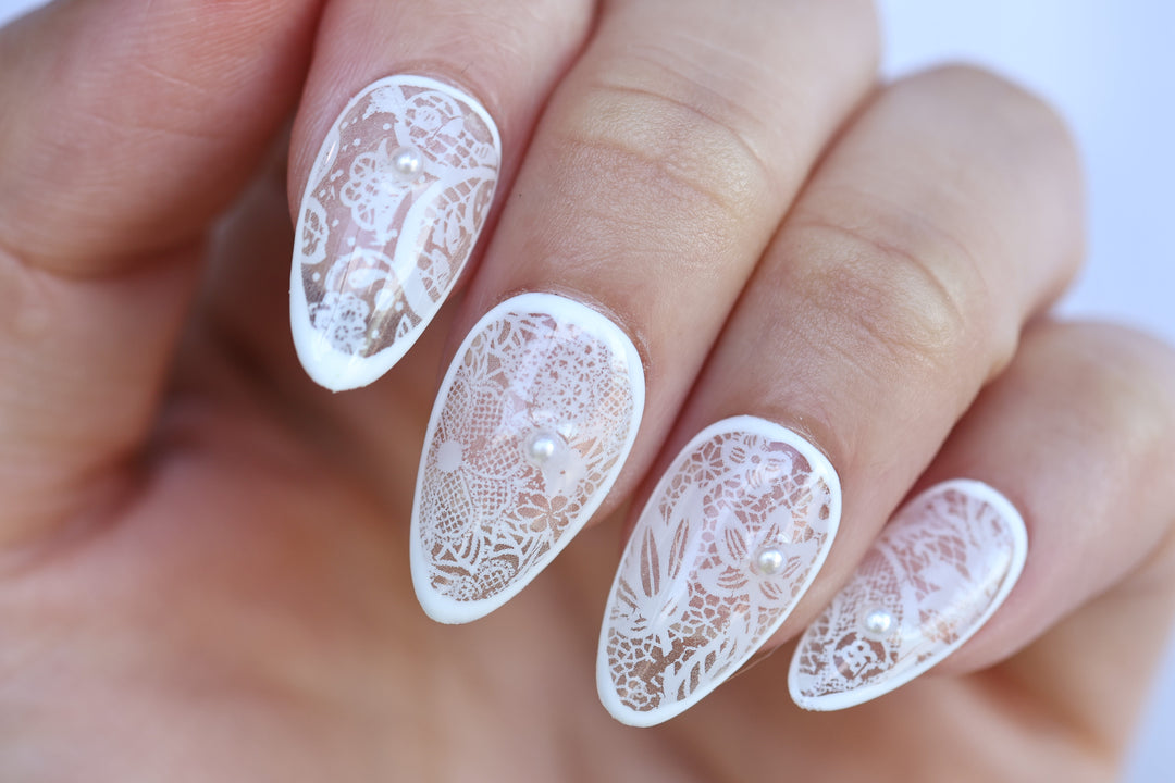 Floral Veil press-on nails worn on hand, white lace floral pattern over sheer base with micro pearls
