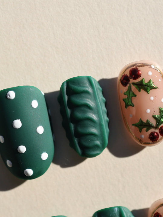 Forest Dots press-on nails laid out: green matte dots, a 3D cable knit nail, and nude holiday accent art.