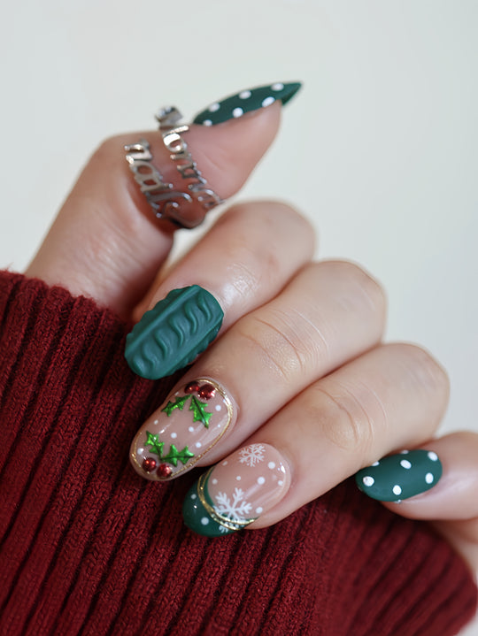 Forest Dots press-on nails worn on hand, green and nude oval nails with polka dots, knit texture and festive holly details