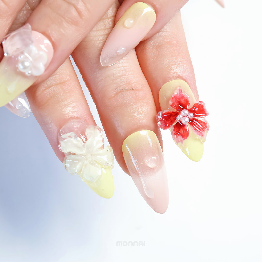 Frost Bloom press-on nails in close-up, showing glossy 3D florals, tiny bead details, and soft pale yellow gradients.