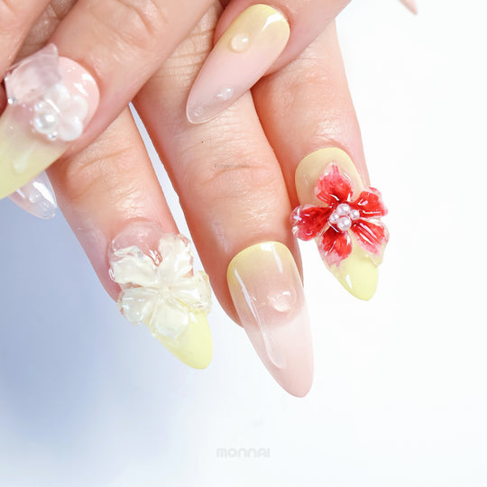 Frost Bloom press-on nails in close-up, showing glossy 3D florals, tiny bead details, and soft pale yellow gradients.