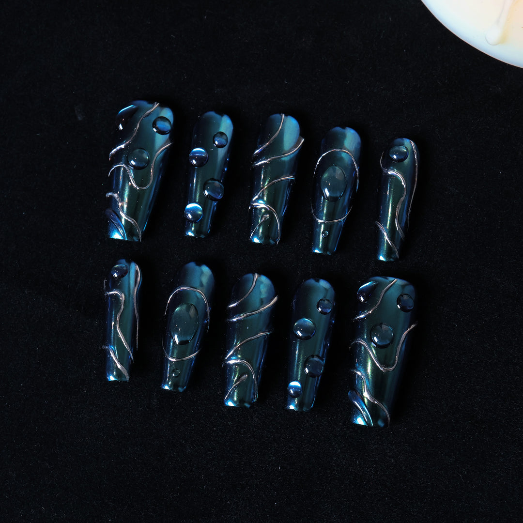 Galactic Shift press-on nails laid out in teal chrome with glossy raised details and fine metallic lines