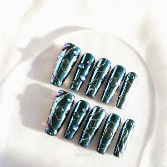 Galactic Shift press-on nails laid out in a sleek futuristic set with teal chrome, glossy raised details, and metallic lines.