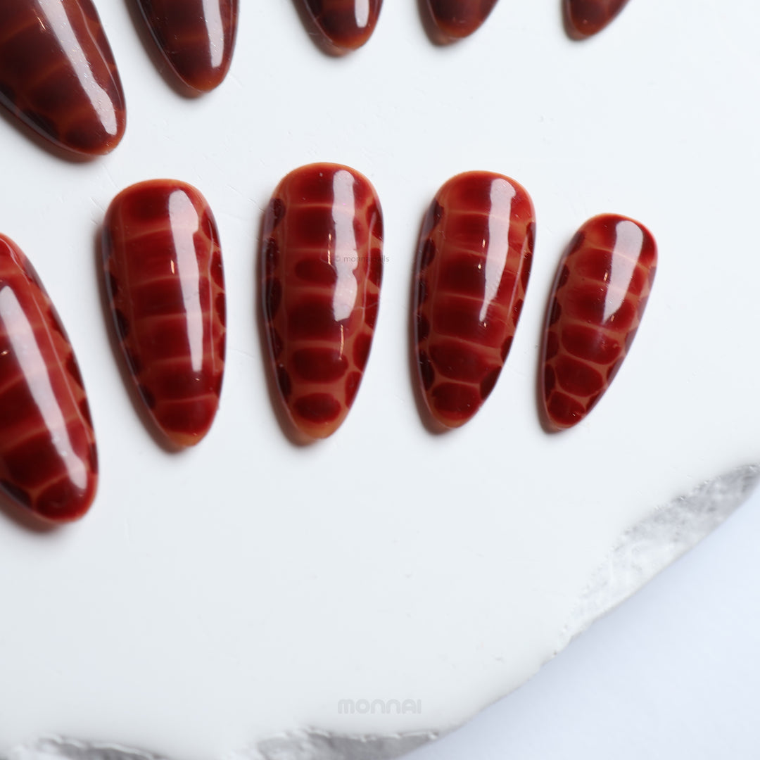 Gator Glaze press-on nails in deep brown crocodile texture, shown in close-up