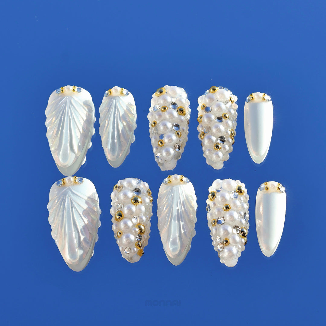 Gilded Pearls press-on nails shown laid out, with pearly shell textures and clustered pearl accents