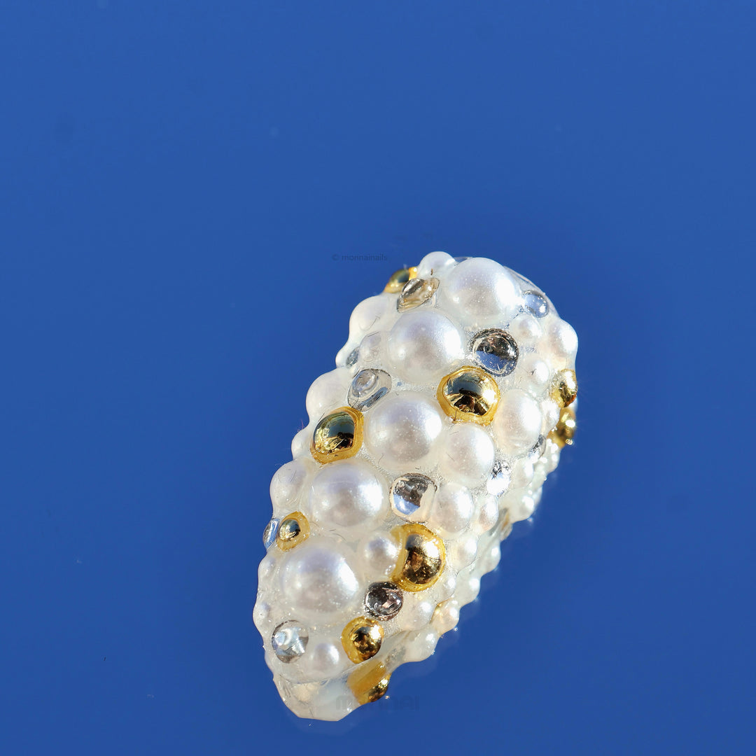 Gilded Pearls press-on nails close-up, milky base with layered pearls and crystal accents