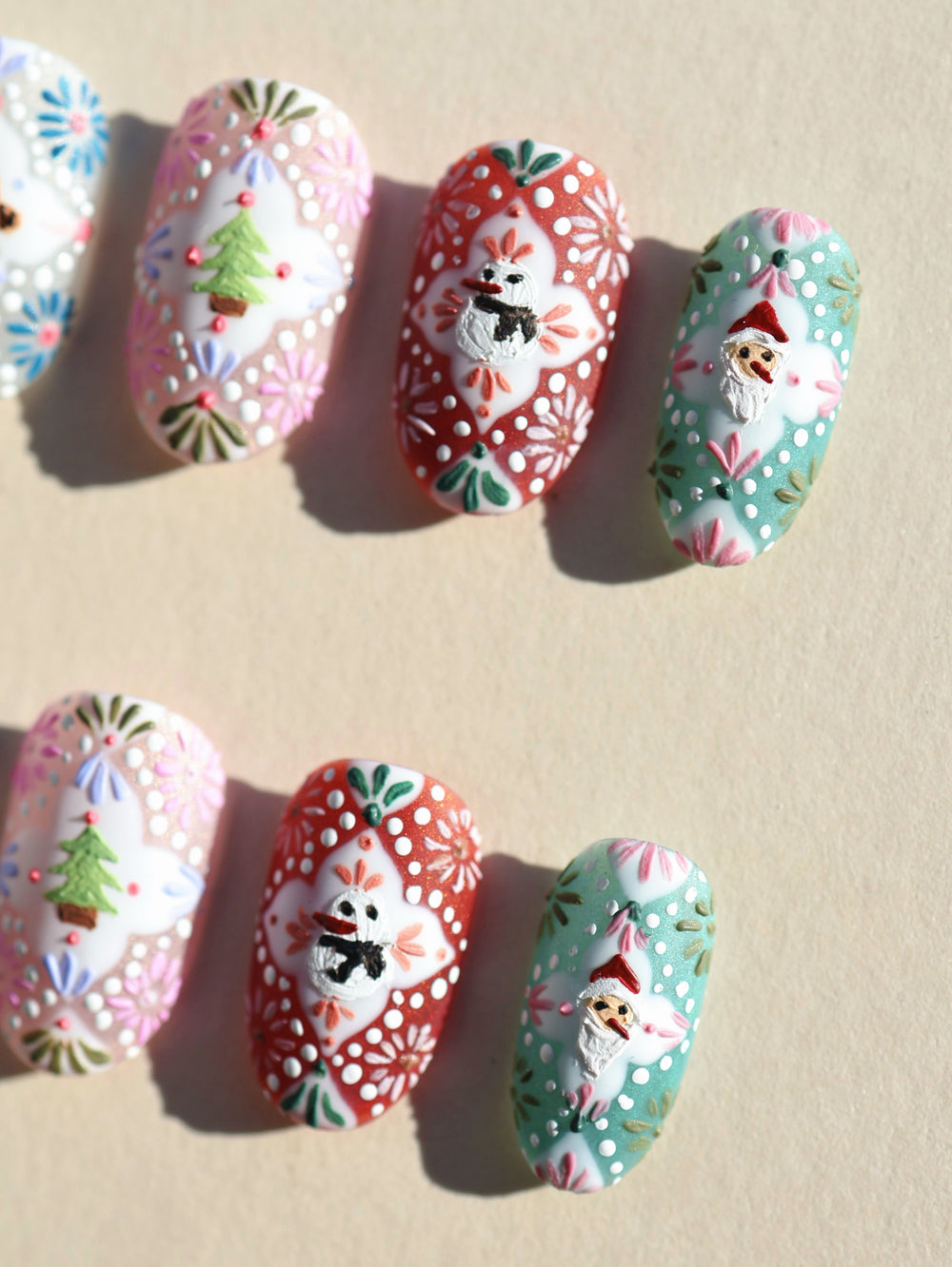 Ginger Cookie Christmas-themed press-on nails laid out with 3D gingerbread, snowman and Santa motifs