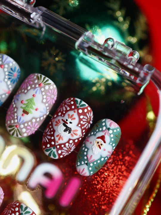 Ginger Cookie Christmas-themed press-on nails laid out, with 3D Santa, snowman and tree motifs in festive pastel red and teal.