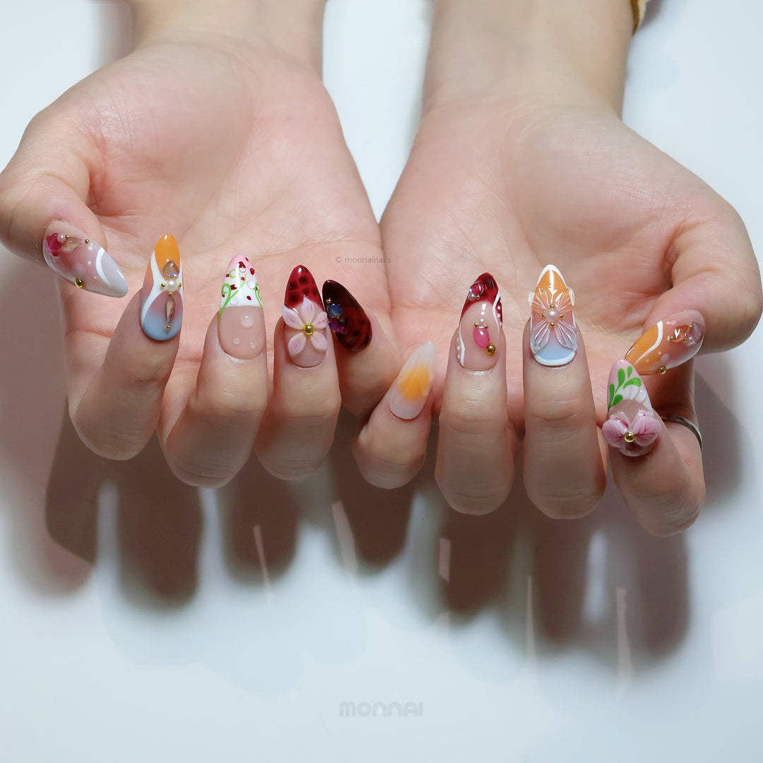 Grace vintage florals press-on nails shown on hands, with nude bases, hand-painted flowers, and gem accents