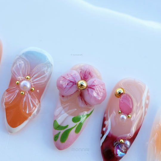 Grace vintage floral press-on nails in close-up, with nude bases, hand-painted flowers, and small gem accents